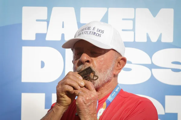 Imagem colorida de Lula beijando medalha - Metrópoles
