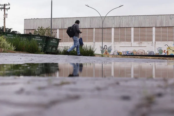 Homem caminha em meio à chuva no DF