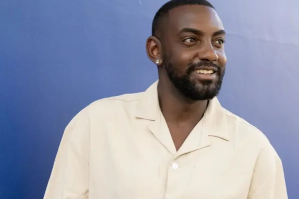 Evandro, Casamento às Cegas posa, olhando de lado, com uma blusa rosinha - Metrópoles