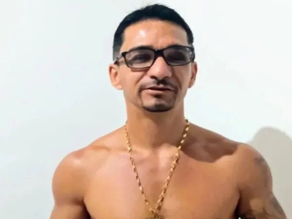 Foto colorida mostra Sergio Luís Pereira, homem branco sem camisa com cordão de ouro e óculos. Ele tem cabelo preto e olha para a câmera - Metrópoles