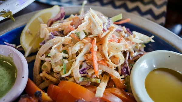 Foto colorida de tigela com salada de repolho e legumes