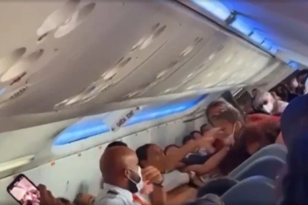 Imagem colorida mostra comissário e confusão entre passageiros. Metrópoles