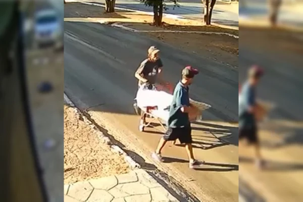 Imagem colorida de dois homens andando em rua do DF