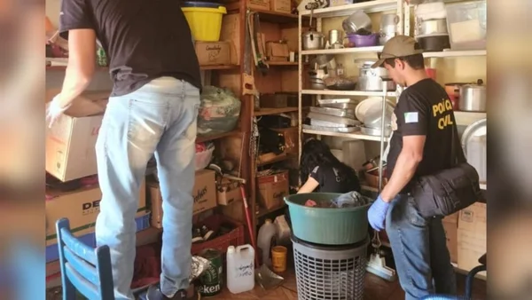 Imagem colorida de policiais periciando local onde o casal mora - Metrópoles