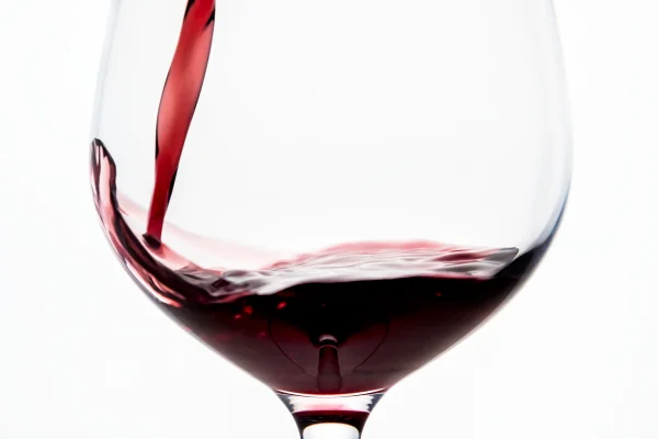 Imagem mostra uma taça sendo enchida de vinho tinto - Metrópoles