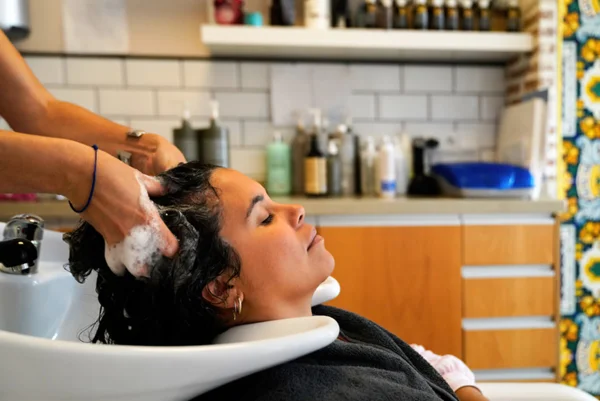 Mulher tem cabelo lavado em salão de beleza - Metrópoles