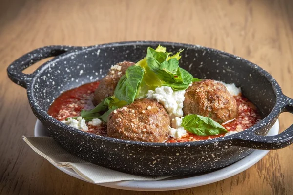 Almondegas vegetariana com molho de tomate e ricota em panela de ferro - metrópoles