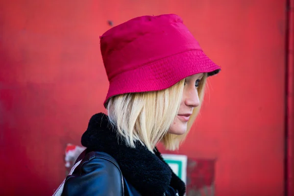 Mulher loira usa bucket hat magenta - Metrópoles