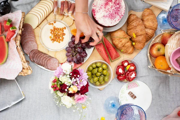 Foto de mesa recheada com pães, frutas, presunto, café, azeitonas e biscoitos - Metrópoles