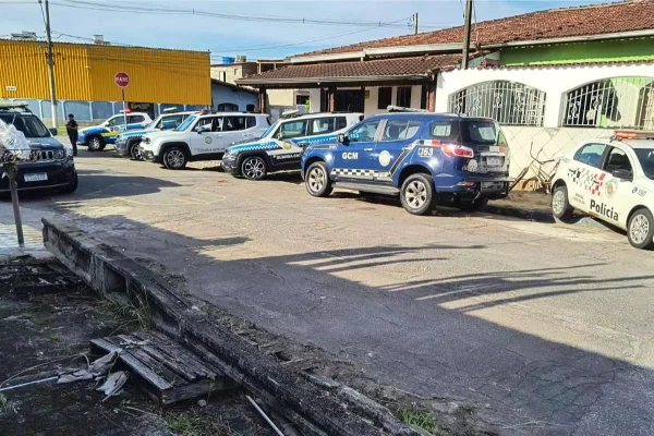 Imagem colorida mostra carros de polícia na rua de casa de guarda civil municipal que foi invadida por suspeito na Praia Grande, litoral paulista - Metrópoles