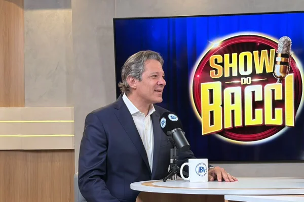 Imagens coloridas mostram Fernando Haddad (PT) em bancada do Show do Bacci durante entrevista