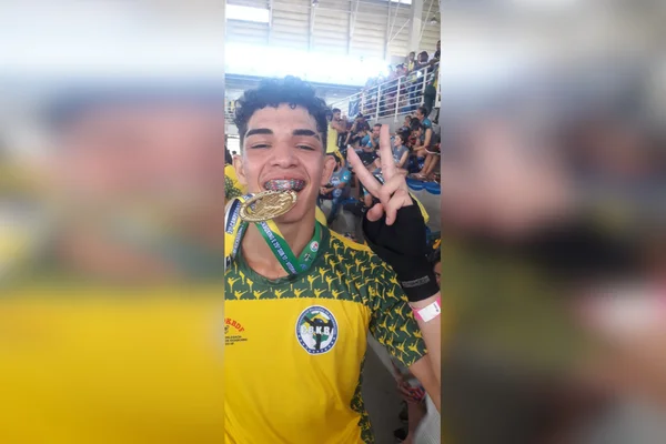 jovem morde medalha e faz sinal de "v"