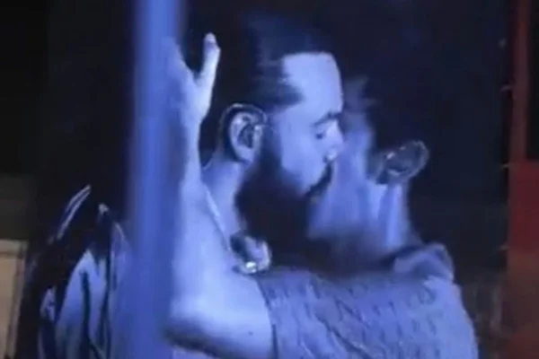 Imagem colorida mostra dois homens se beijando