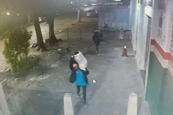 Imagem colorida,criminosos saindo com sacos lotados de suprimentos da creche - Metrópoles