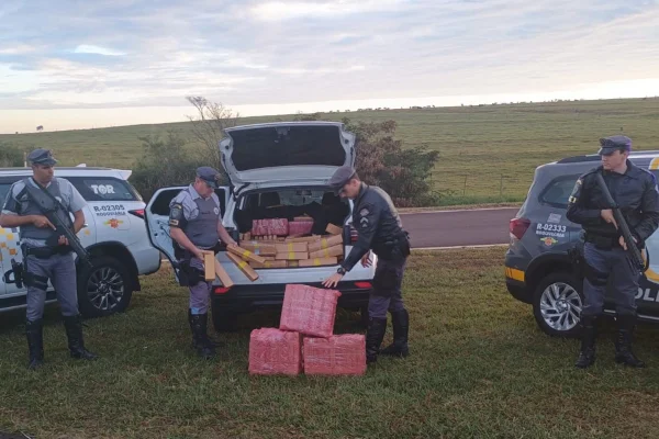 Imagem mostra policiais desembarcando droga de veículo - Metrópoles