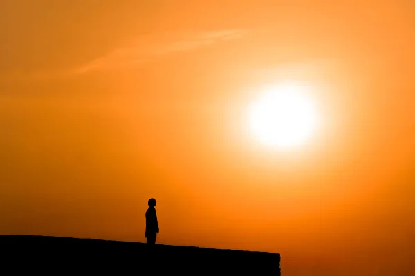 imagem amarela pôr do sol com silhueta de uma pessoa