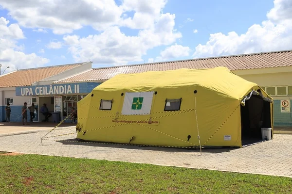 Tenda amarela em frente a prédio de UPA