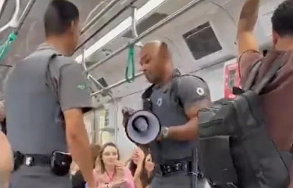 foto colorida mostra dois agentes de segurança da ViaMobilidade dentro de um trem da Linha 9 dançando; um deles segura um megafone - Metropoles