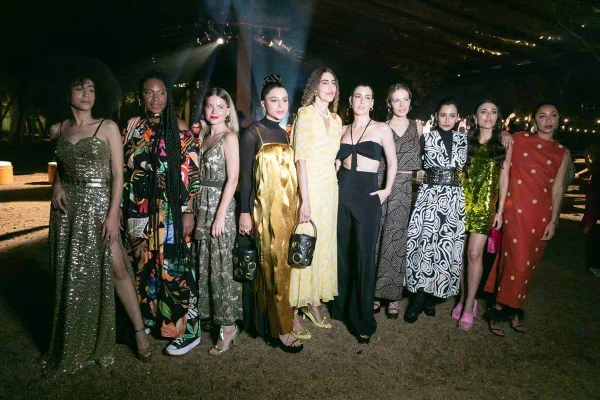 Na imagem com cor, influenciadoras posam para fotos durante o evento da Shop2gether