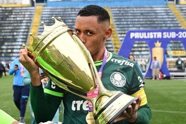 Foto colorida de Michel Augusto, jogador do Palmeiras, beijando a taça - Metrópoles