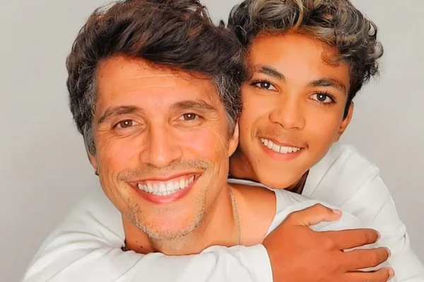 Na foto, um homem segurando um menino no colo - Metrópoles