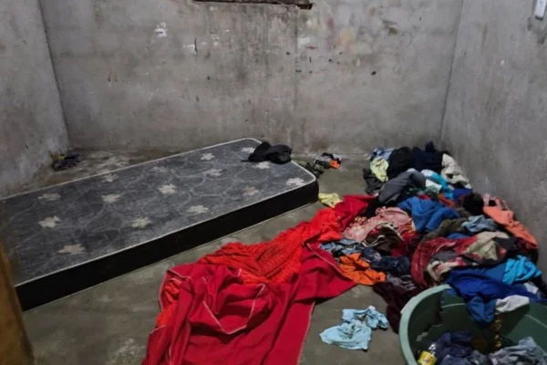 Imagem colorida de colchão e roupas jogadas no chão