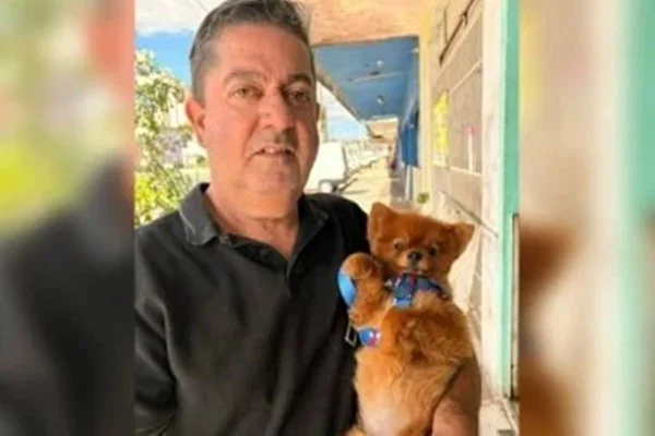 Imagem de homem segurando um cachorrinho