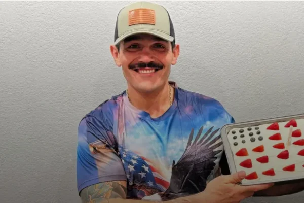 Brasileiro com boné segura travessa de bolo