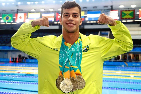 Na imagem colorida, Guilherme Costa, o Cachorrão, aparece com medalhas no pescoço - Metrópoles