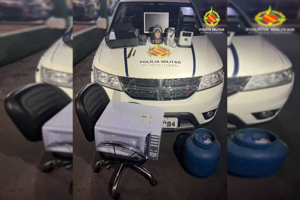Viatura da PMDF estacionada com objeto retangular em cima de cadeira de escritório e botijão de gás azul ao lado