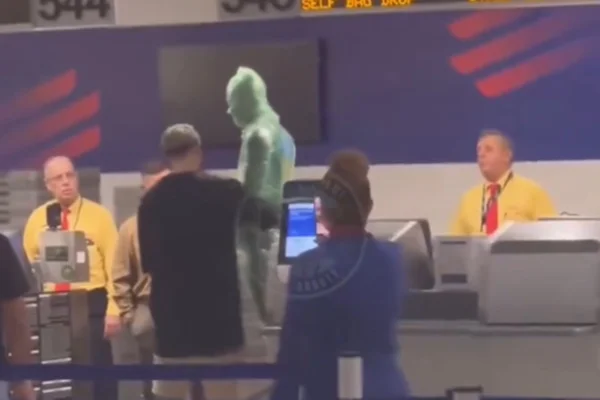 Imagem colorida de homem se enrola em plástico para ser despachado - Metrópoles
