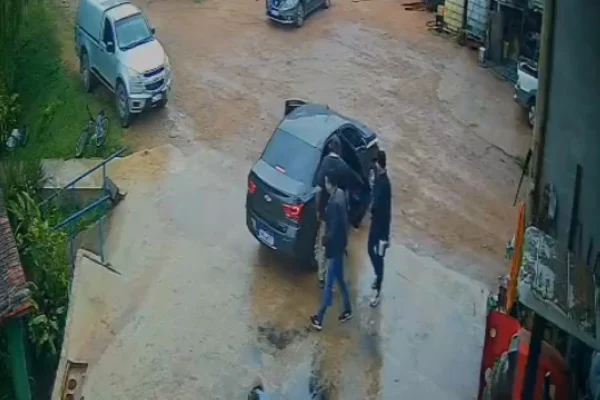 Imagem colorida de homem sendo colocado em carro em "sequestro". Metrópoles