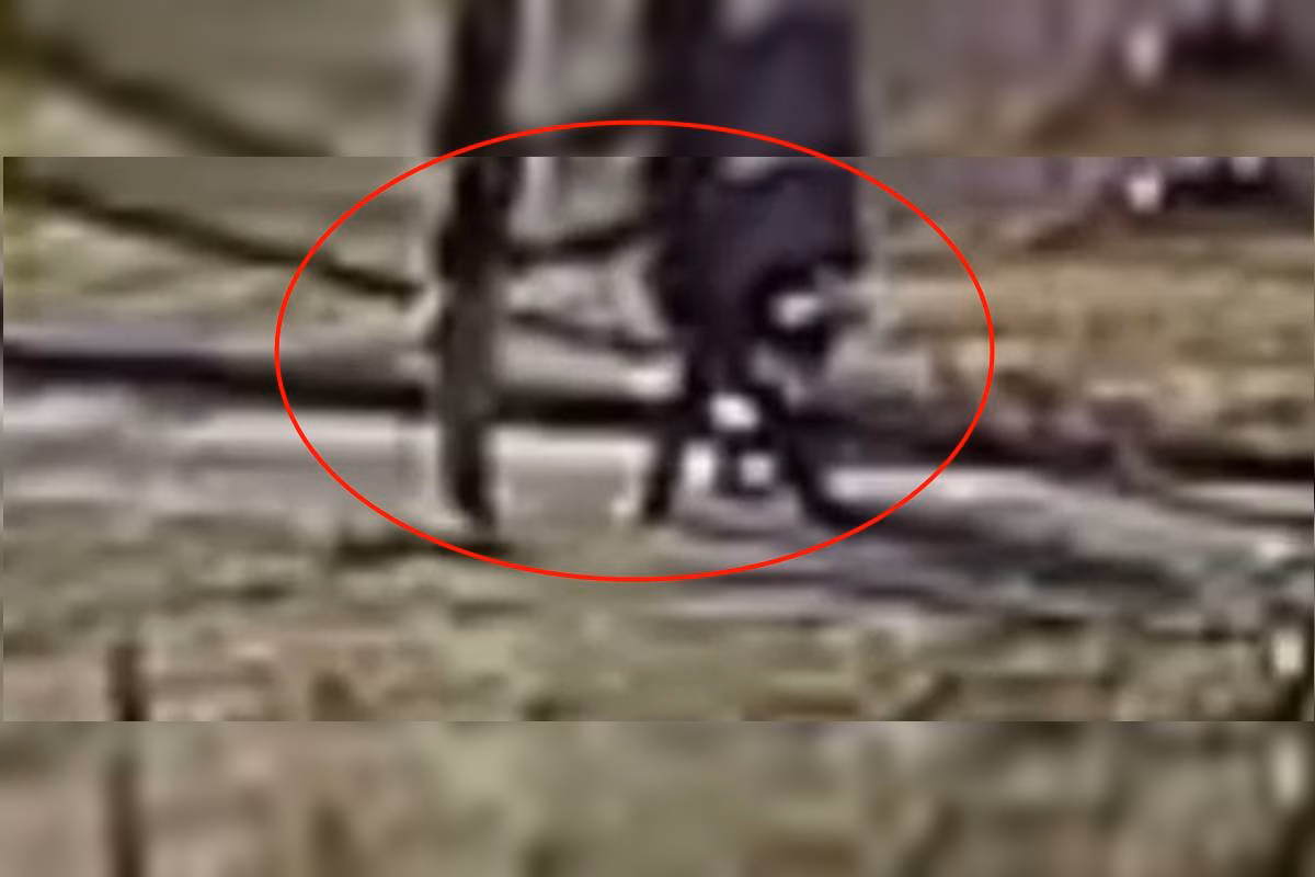Foto colorida do momento em que uma mulher é levada para uma área de mata e estuprada