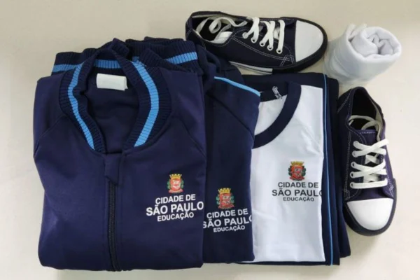 imagem colorida mostra kit de uniforme escolar com blusa de frio, camiseta, tênis e meia - metrópoles