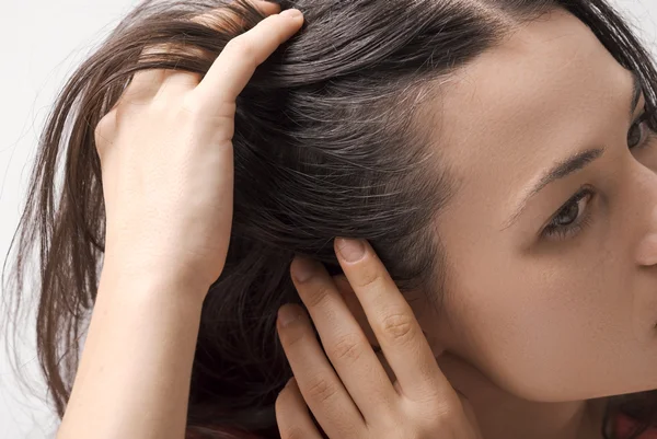 Jovem mulher mostrando frios brancos de cabelo - Metrópoles