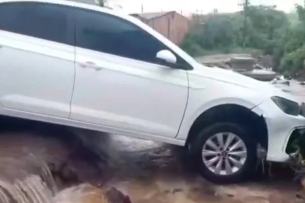 Carro é levado por enxurrada e fica preso em vala durante chuva no DF