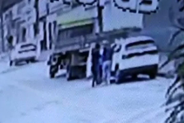 Imagem colorida mostra duas pessoas abordando um carro branco da equipe de segurança de Lula, em São Bernardo do Campo - Metrópoles