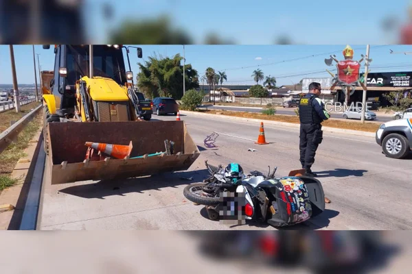Imagem colorida de uma moto caida em frente a uma retroescavadeira - Metrópoles