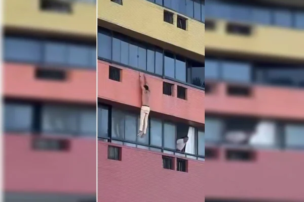 homem pendurado em janela