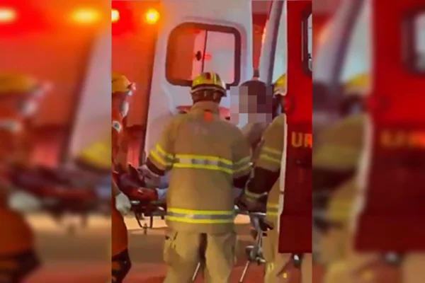 Foto colorida de pessoa sendo socorrida pelos bombeiros