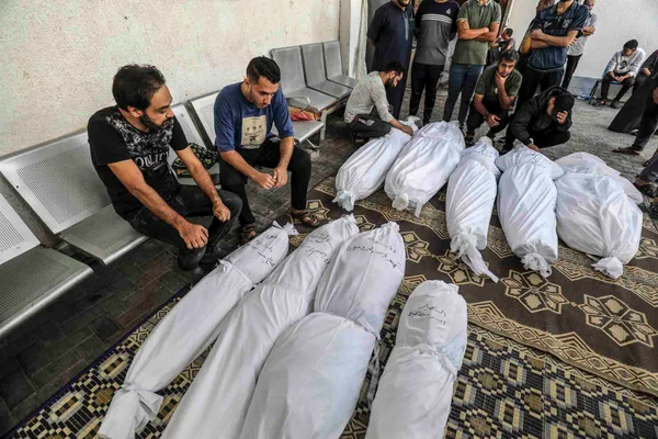 Os palestinos se reúnem em torno dos corpos vítimas dos ataques aéreos israelenses - Metrópoles