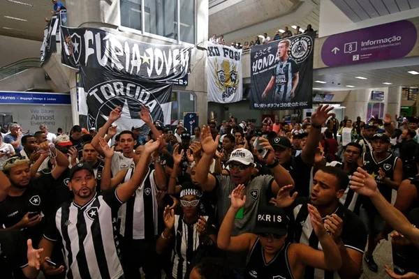 Vídeo. Torcida do Botafogo enche aeroporto para receber Honda