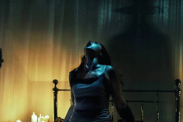 Imagem colorida de uma mulher morena que veste uma camiseta branca. Cena do filme O Último Ritual - Metrópoles