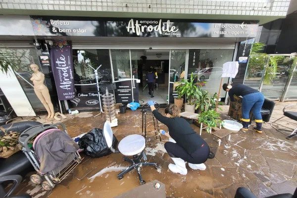 Imagem colorida de mutirão de limpeza em frente a comércio de Porto Alegre (RS) gaúchos se adaptam - desenrola Metrópoles