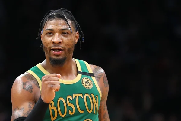 Marcus Smart com tranças e o punho fechado