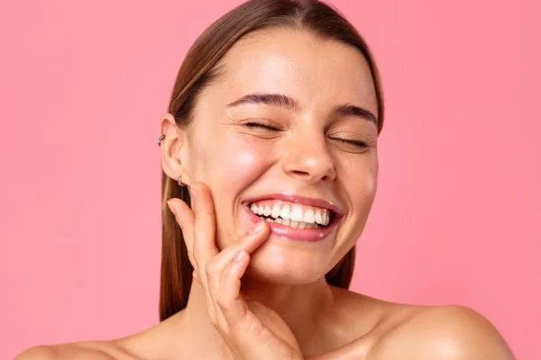 Mulher sorrindo com a mão no rosto
