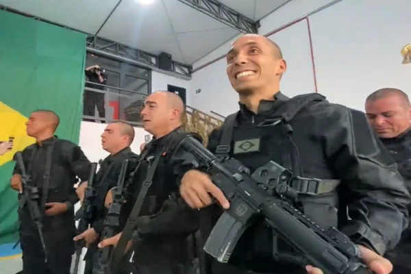 policial segura arma e sorri
