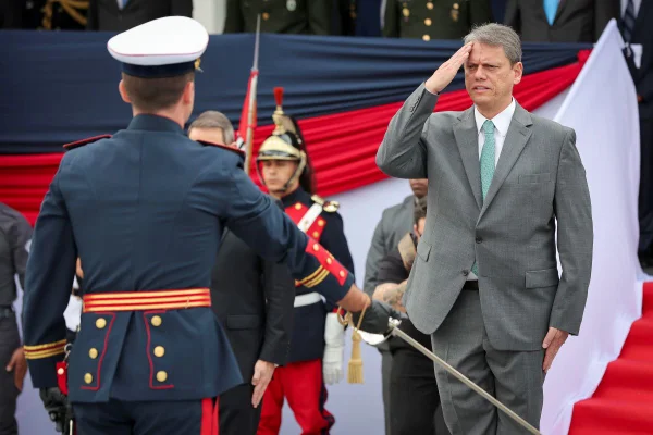 Foto colorida de Tarcísio de Freitas prestando continência em solenidade militar