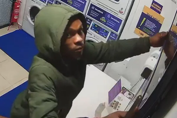 homem com capuz segura televisão