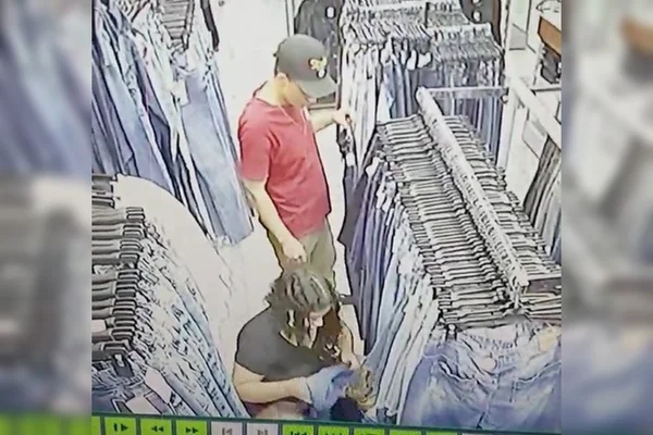 Homem e mulher entre roupas jeans em loja